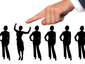 Hand pointing to person in a line of people