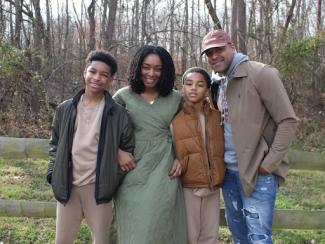 black family standing for portrait in a forest