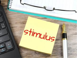The word "stimulus" written on post it note on desk
