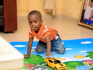 Child playing with toy car on mat