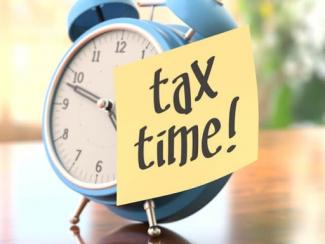 Alarm clock with "tax time" sticky note