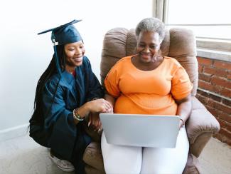 College graduate watching with senior woman