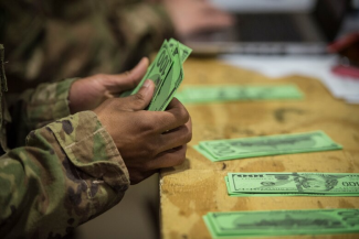 An Airman counts out fake money