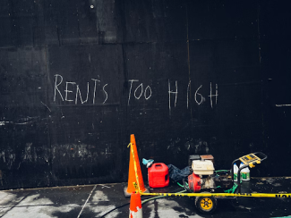 "Rent's Too High" written on wall