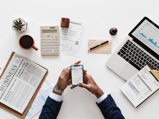 person holding phone at a work desk