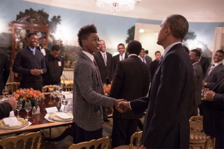 Former President Barak Obama shakes hands with young man