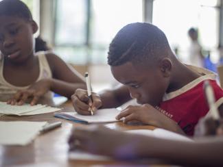 Kids writing on paper at table