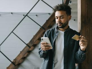 Man holding credit card and cell phone