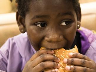 Young girl eating hamburger
