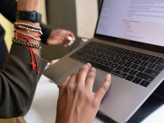 Open laptop with hands on keyboard