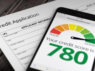  Paper credit application on desk with mobile phone showing credit score