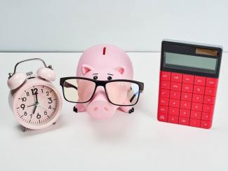 An alarm clock, piggy bank and calculator