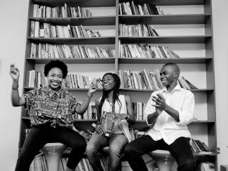Two women and man sitting on chair