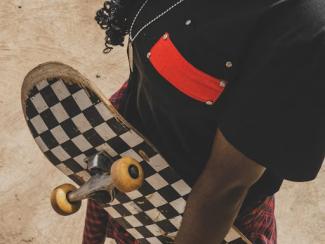 Black person holding skateboard