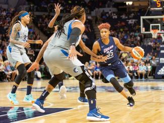 Atlanta Dream basketball player and other WNBA players in play