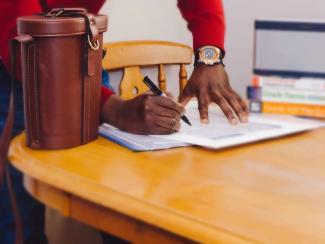 Person signing papers at table