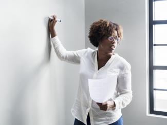 Woman writing on whiteboard