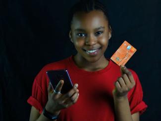 Woman holding credit card and cell phone