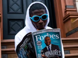 Person reading Forbes Magazine