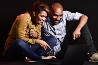 Couple smiling at computer screen