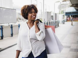 black women with white shopping bags over her shoulder