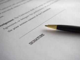 Pen laying on the signature line of a contract