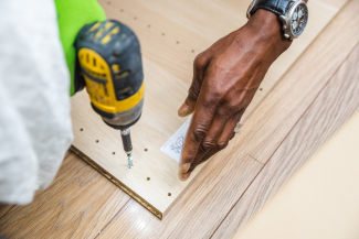 Black person assembling wood craft