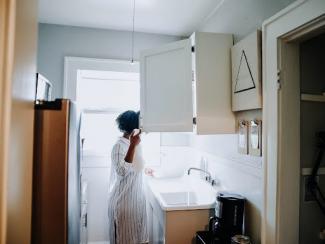 Woman looking in kitchen cabinet