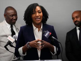 black woman speaking in front of a microphone