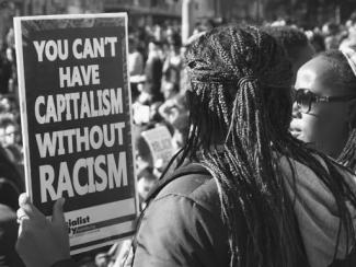 black people holding a sign that says you cant have capitalism without racism