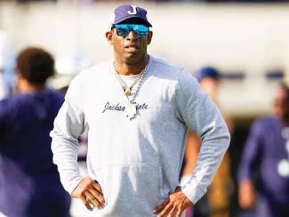 coach prime standing with jackson state long sleeve and hands on hips
