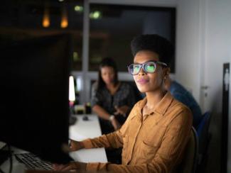 black woman sitting at a computer 