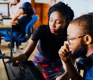 woman and man sitting in front of a monitor