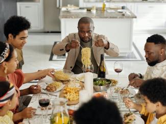 black family sitting at a table eating pasta 