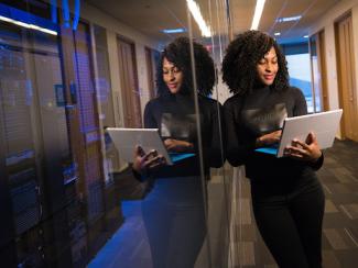 black woman holding laptop and smiling