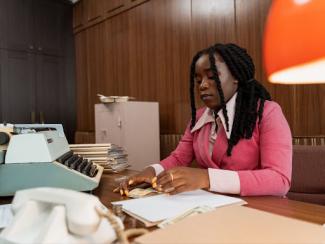 A woman at desk counting cash