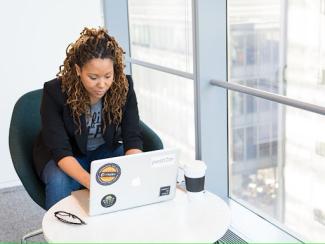 black woman sitting down with a laptop in front of her