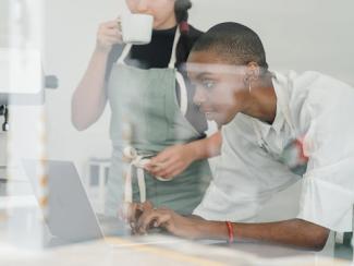 two people looking at a laptop