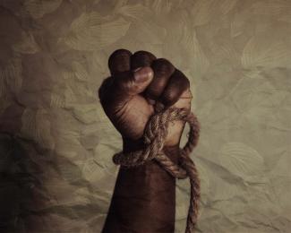 Fist raised with rope around wrist