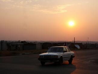 car driving with the sun setting