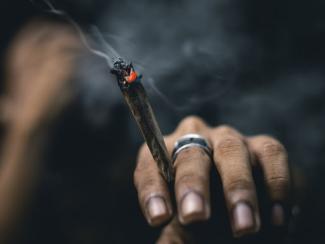 person holding a joint in between their fingers