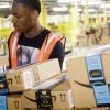 black male amazon worker handling amazon packages