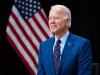 president joe biden standing in front  the us flag