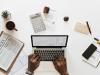 Laptop on desk surrounded by office supplies
