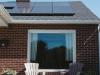 brown brick house with solar panels on roof