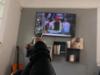 Person pointing remote at TV