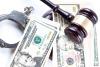 Money scattered over handcuffs and gavel