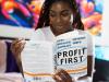 black woman reading a book titled profit first
