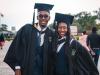 two black graduates in graduation gowns smiling