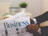 person holding a business newspaper